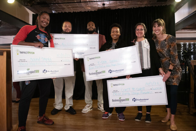 Impact Pitch winners with giant checks