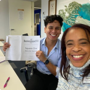 Business coach with a student in a classroom for Square One course.