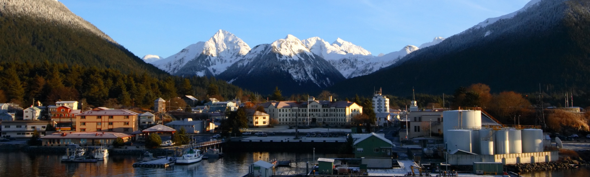 A landscape photo of rural Sitka, Alaska over the water with boats.